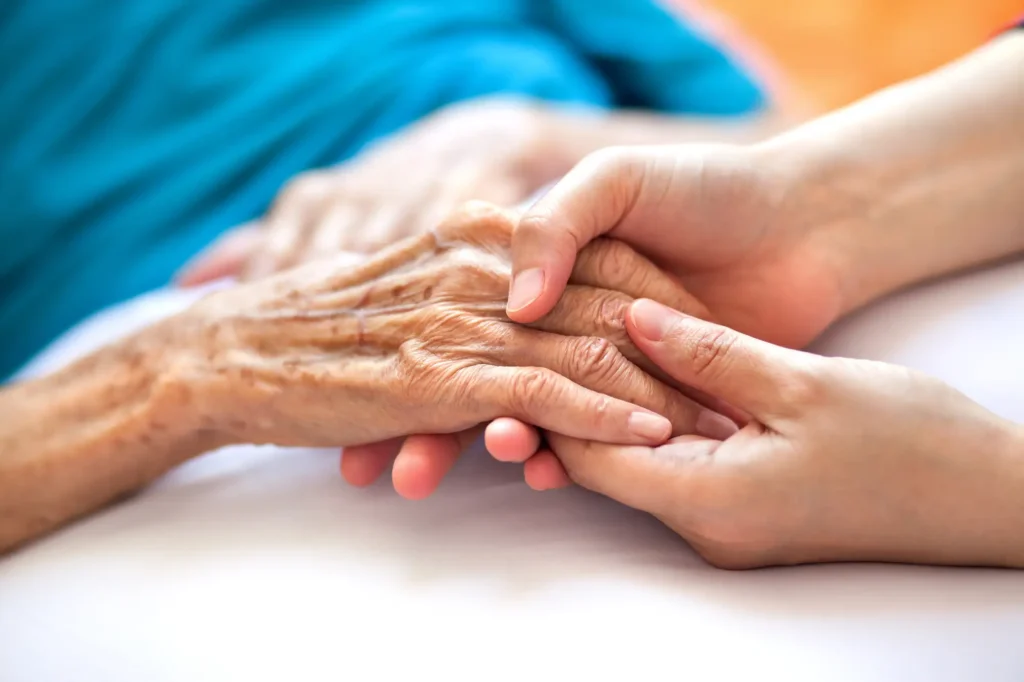 closeup of someone holding senior's hands