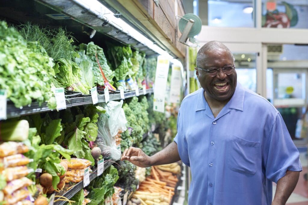 senior gentleman grocery shops at Whole Foods