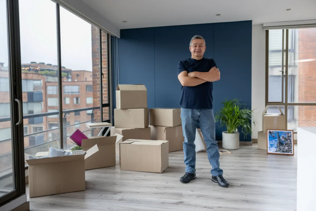 Latin American man moving house and packing in boxes
