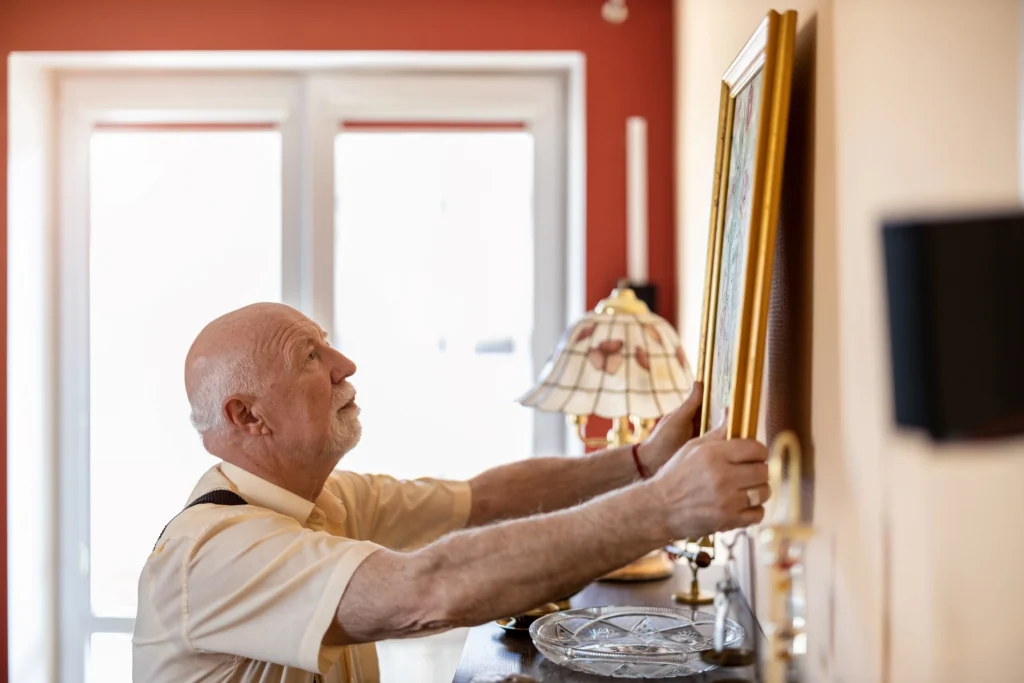 Senior man decorating a senior living apartment 