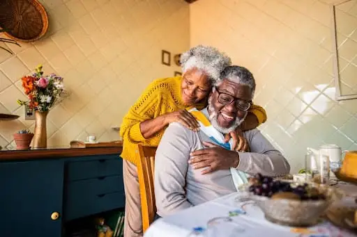 A happy senior couple hugging from the residence of their home at The Merion in Evanston, IL.