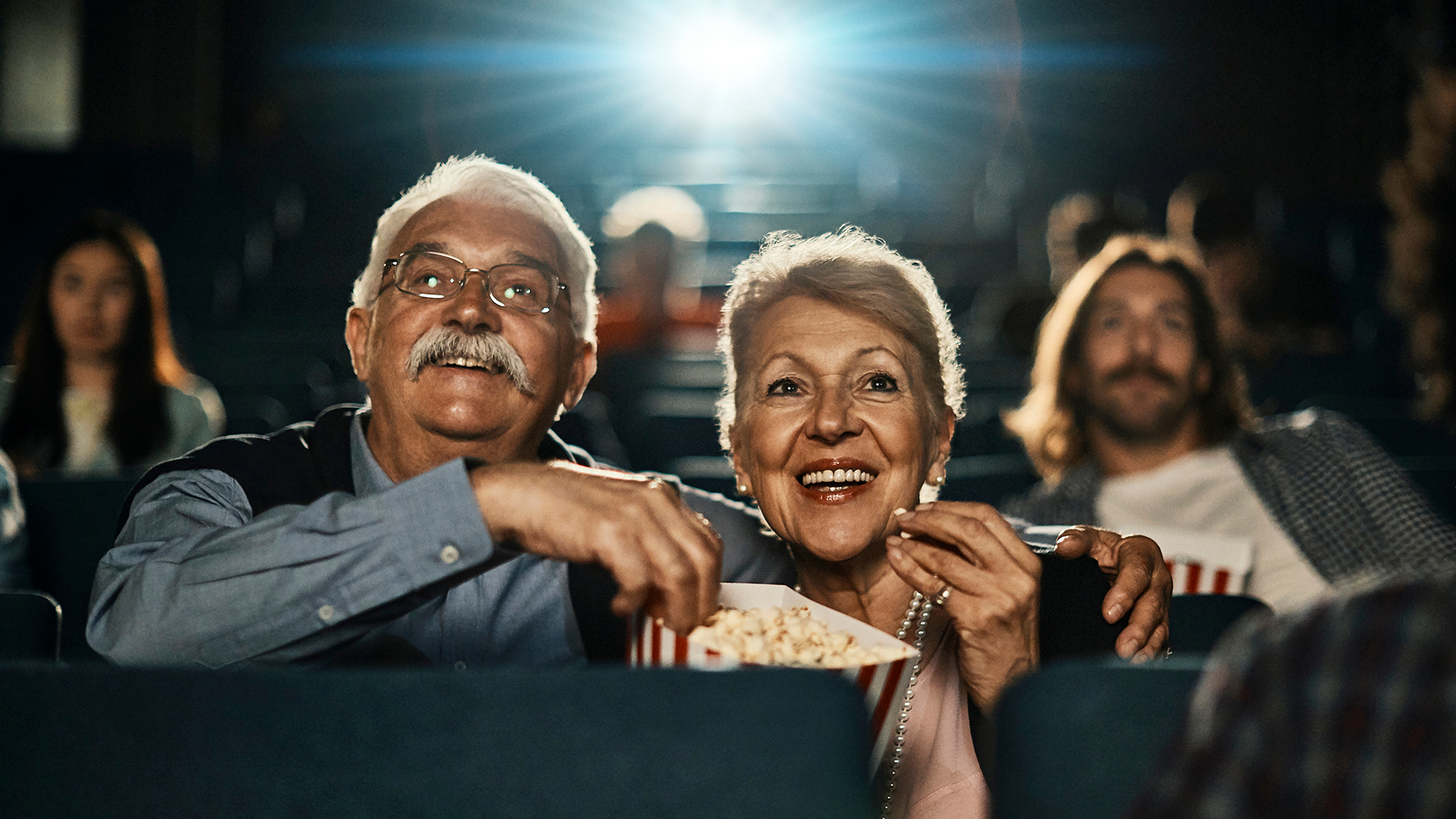 seniors at the thearter with popcorn watching movies about retirement