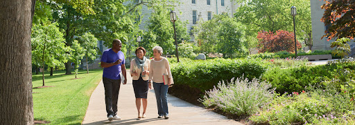seniors walking outdoors on campus with books